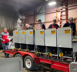 Cooks preparing a fish fry at mobile stovetops.