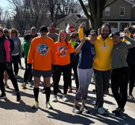 A group of people who are participating in a 5K run posing for the camera.